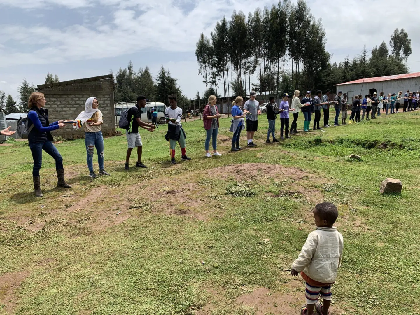 A group of people standing in the grass.