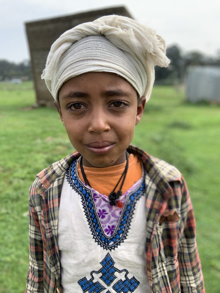 A young boy wearing a turban and necklace.