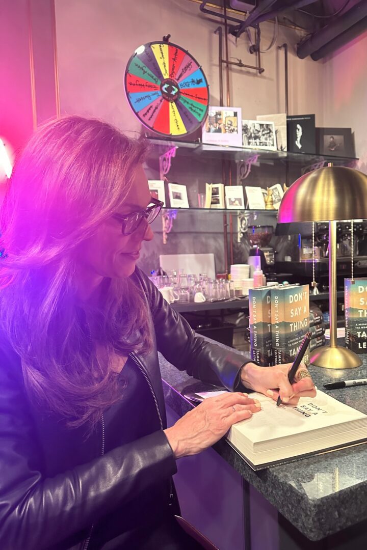 A woman writing in her notebook at the counter.
